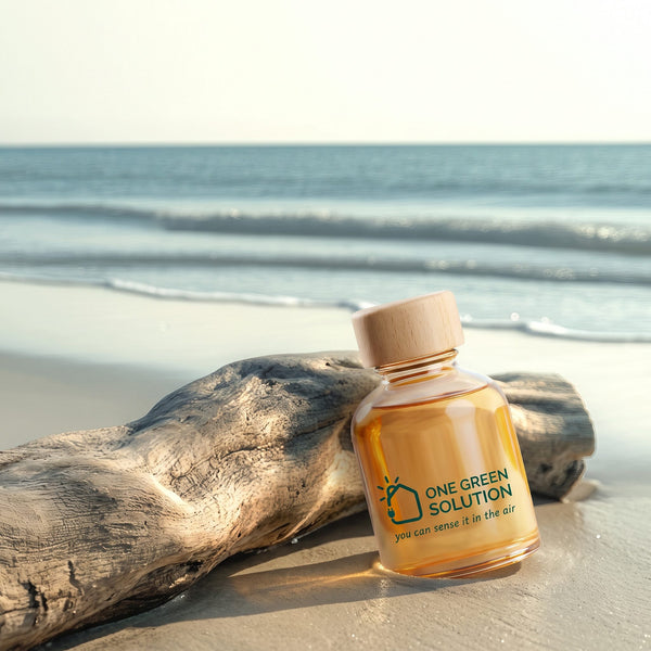 Ocean Aria Signature Scent oil bottle resting on driftwood at the edge of the sea