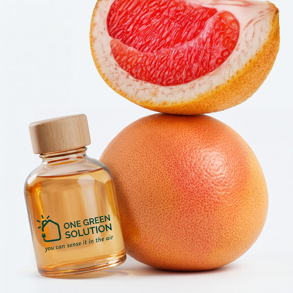 Pink Grapefruit Signature Scent oil bottle next to a whole pink grapefruit and a juicy wedge